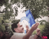 a man holding a blue flag with a white circle on it
