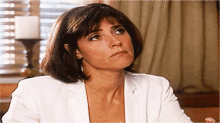 a woman in a white jacket looks up at the sky