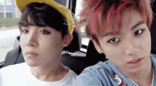 two young men are sitting next to each other in a car