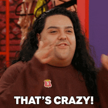 a man with long hair says that 's crazy while wearing a brown shirt
