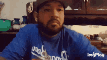 a man with a beard wears a dodgers shirt