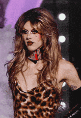 a woman in a leopard print dress has a tattoo on her arm with the number 10