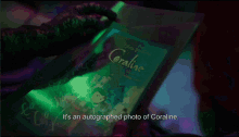 a person is holding a book that says coraline