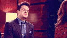 a man in a suit with his eyes closed