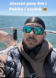 a man wearing sunglasses is on a boat with the words jeszcze parę km i polska i zasilek below him