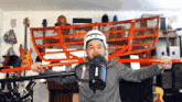 a man wearing a helmet and a shure microphone is holding a red oar