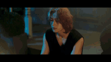 a man with long hair is wearing a black top