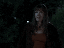 a man in a blue shirt looks at the moon in the dark