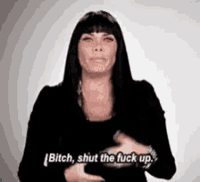 a woman is making a funny face and saying bitch shut the fuck up .