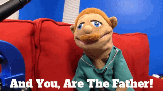 a puppet sitting on a red couch with the words 