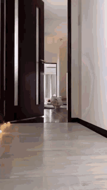 a hallway with candles on the floor and a door open .