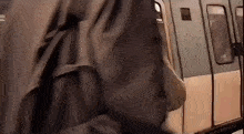 a person is getting on a subway train with their backpack .