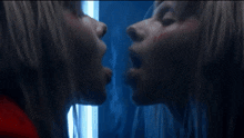 a woman 's face is reflected in a mirror with a blue background