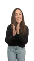 a woman wearing a black shirt and jeans is clapping her hands