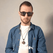 a man wearing sunglasses and a denim shirt has the word edh on the bottom right