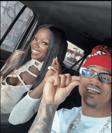 a man wearing glasses and a red bandana is smiling next to a woman