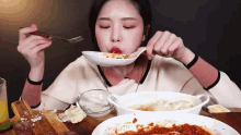 a woman is eating spaghetti with a fork from a bowl .