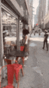a blurry picture of people walking down a sidewalk in front of a store