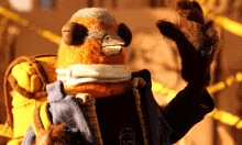 a stuffed animal wearing a scarf and gloves waves his hand