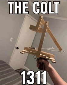 a person is holding a wooden gun that says the colt 1311 on it