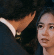 a man and a woman are looking at each other . the woman is looking at the man 's face .