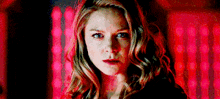 a close up of a woman 's face in front of a red background .