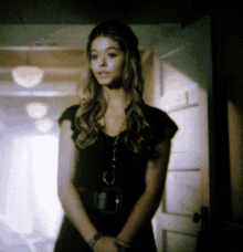 a woman in a black dress is standing in a hallway