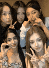 a group of young women are posing for a picture and one of them is wearing a ring on her finger