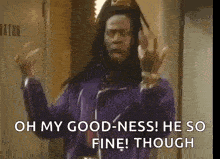 a man in a purple jacket is standing in a hallway and says `` oh my goodness ! he so fine ! though ''