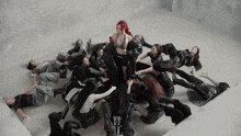 a woman with red hair is surrounded by a group of dancers wearing black and white