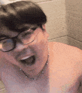 a shirtless man wearing glasses and a chain around his neck is making a funny face
