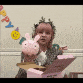 a girl with pink hair is holding a pink bunny in front of a sign that says happy