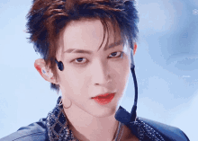 a close up of a young man wearing a microphone and a necklace