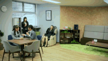 a woman sits in a chair with her eyes closed while two women sit around a table talking