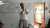 a man stands in front of a white board that says laedma
