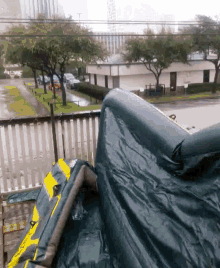 a view of a city from a balcony with a green tarp on the ground