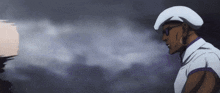 a man in a white hat and sunglasses is standing in front of a dark cloudy sky .