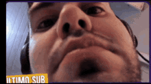 a close up of a man 's face with headphones and a sign that says ultimo sub