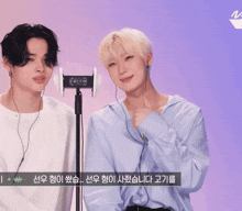 two men wearing ear buds are standing next to each other in front of a purple background