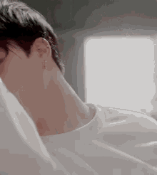 a close up of a person 's neck and ear with a white shirt on .