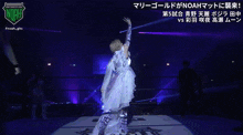 a woman in a white dress stands in a wrestling ring with a noah logo on the top