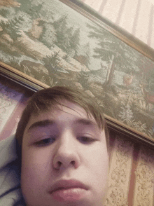 a young man laying in front of a framed picture
