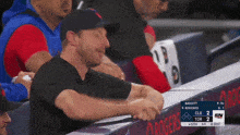 a man sits in the dugout watching a baseball game between cle and tor