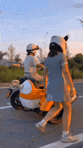 a man and a woman are riding a motorcycle on a road .