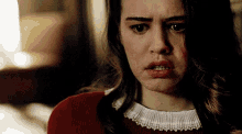 a woman in a red sweater with a white lace collar