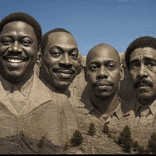 a group of four men are standing next to each other smiling