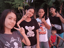 a group of people posing for a picture with one girl wearing a shirt that says " i 'm ts "