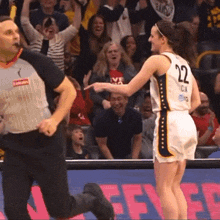 a female basketball player wearing a number 22 jersey talks to a referee