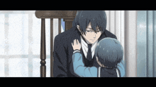 a man in a suit and tie holds a little boy in his arms