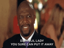 a man in a suit and tie is smiling and says damn lil lady you sure can put it away